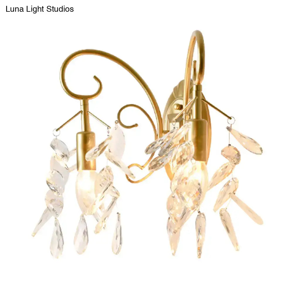 Contemporary brass wall mount light with gold-toned curved arms and cascading clear teardrop crystal wall pendants