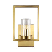 Contemporary brass wall light with a clear glass cylinder and exposed bulb light fixture for bedroom use