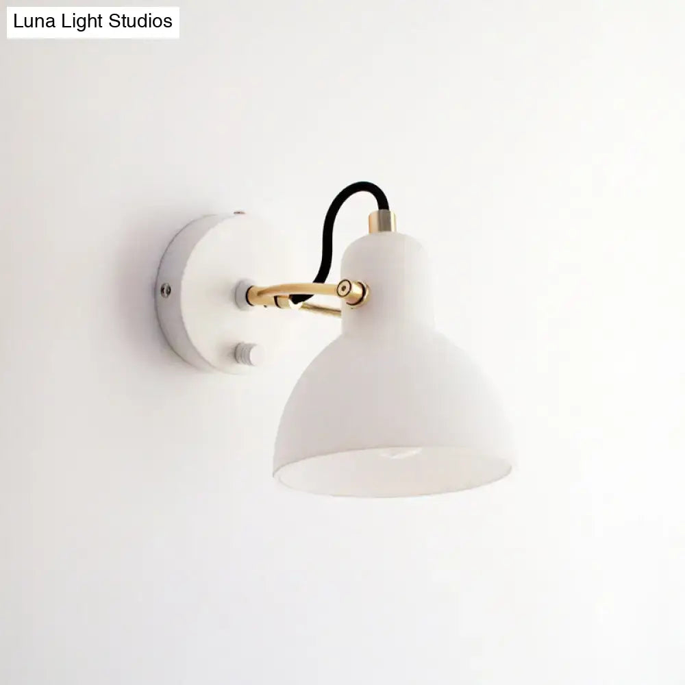 Contemporary wall lamp with white glass domed shade and brass-finished articulated arm for bedroom use