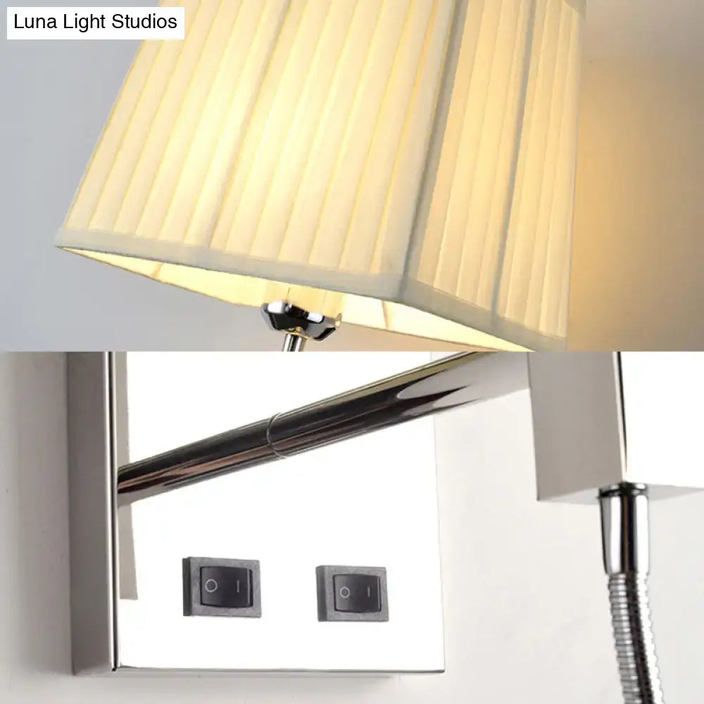Cream-colored pleated lampshade on a contemporary chrome light fixture with adjustable arm and spot light bedroom sconce