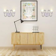 Contemporary silver curved wall sconce with two upward lights and central circular accent for bedroom lighting
