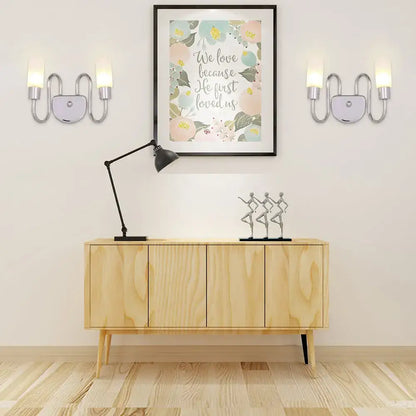 Contemporary silver curved wall sconce with two upward lights and central circular accent for bedroom lighting