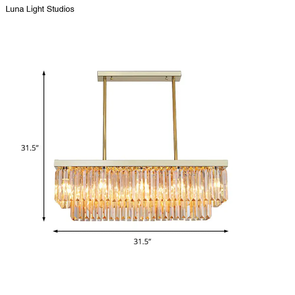 A modern rectangular chandelier light fixture with gold metal frame and clear amber crystal prisms for dining room use