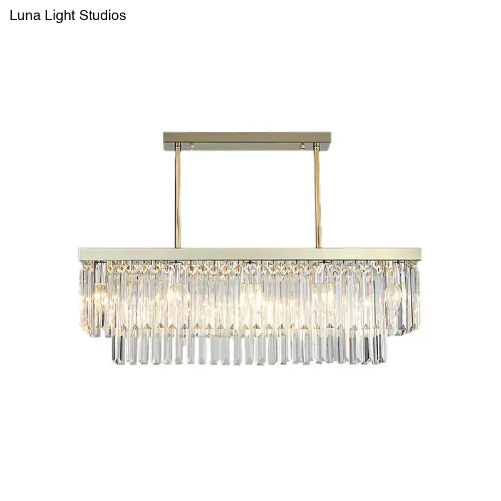Contemporary rectangular dining room light fixture with brushed gold frame and cascading clear amber crystal prisms