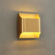 Contemporary copper brass wall sconce in gold with sleek metallic finish and curved edges for living room decorbites