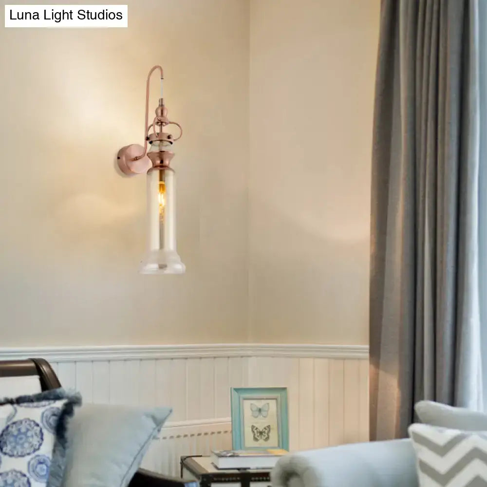 Contemporary rose gold-toned wall sconce with smoke gray amber glass shade and frosted glass base for bedroom lighting