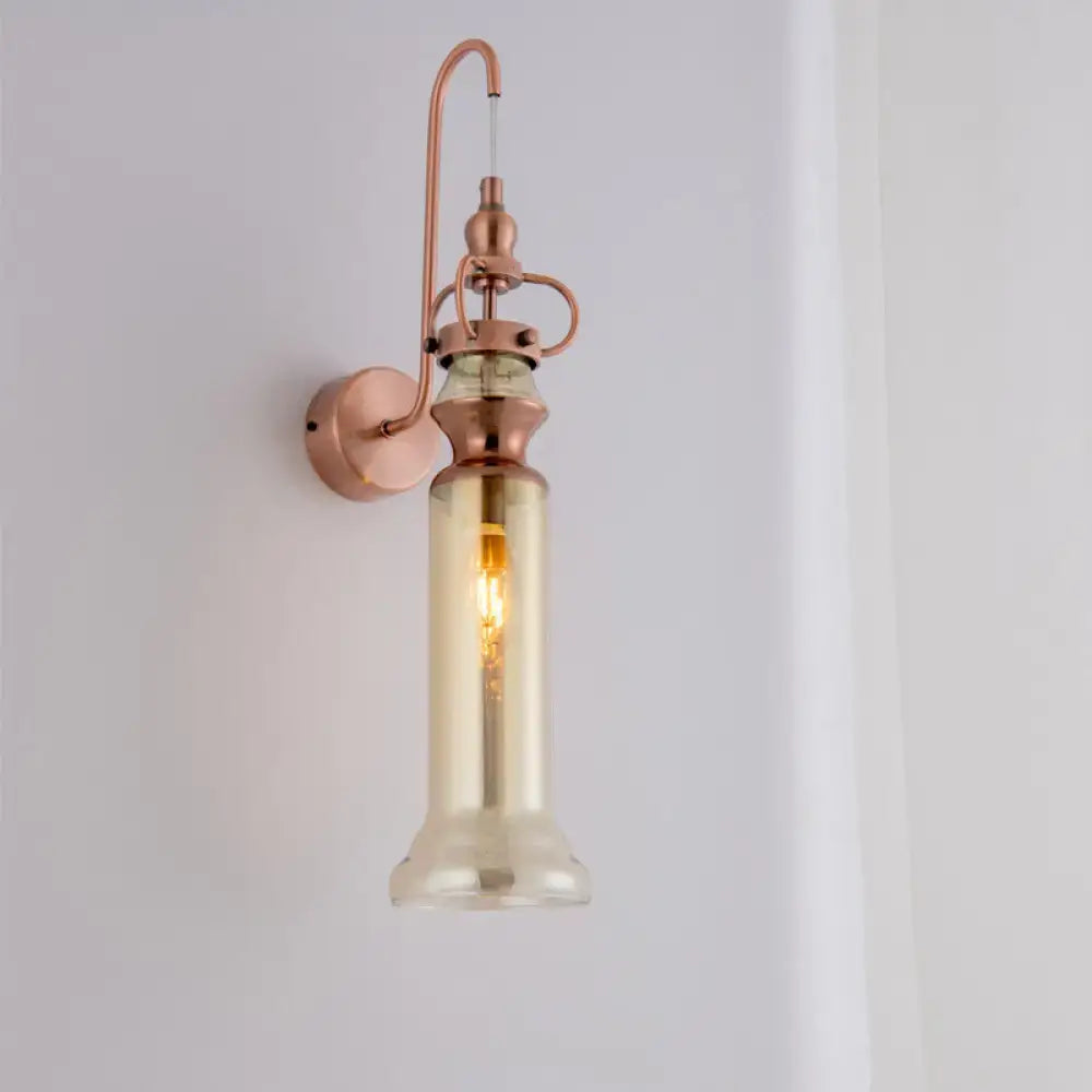 Contemporary copper wall sconce with gray amber tall glass shade and exposed filament bulb for bedroom lighting