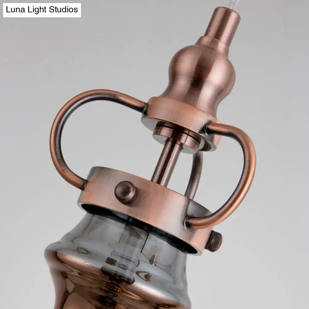 Contemporary copper wall sconce with smoke gray amber glass shade in industrial style for bedroom lighting