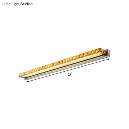 A sleek 22-inch contemporary crystal gold wall sconce with polished chrome and faceted amber crystals featuring warm white LED light