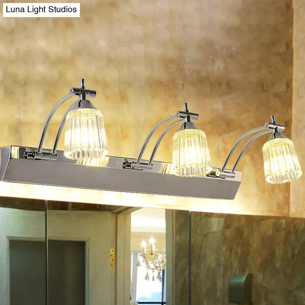 Lámpara de tocador contemporánea DecorBites™ de cristal: pantallas de cristal transparente acanaladas, acabado plateado, 3 cabezales, luz cálida/blanca.