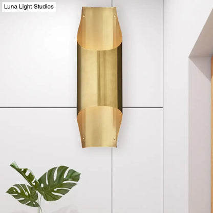 Contemporary curved brass wall lamp with sleek bulb base for modern living room with minimalist design