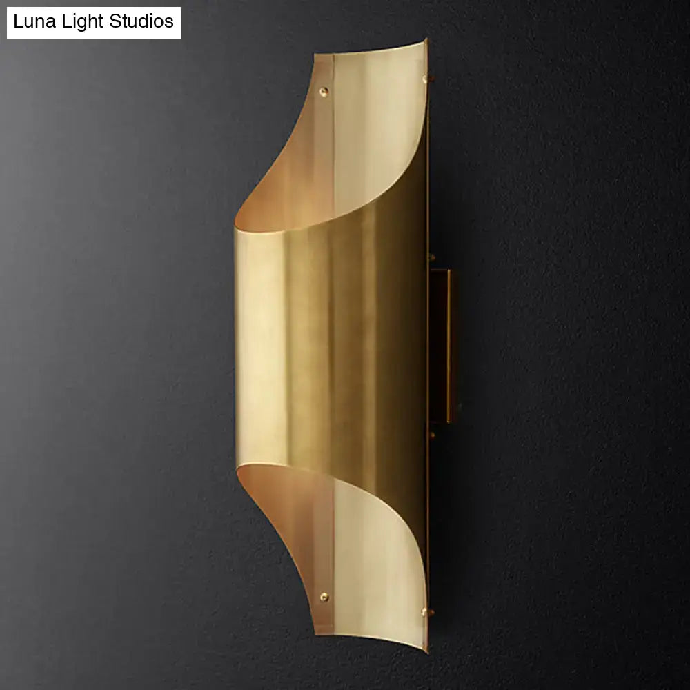 Contemporary curved brass wall lamp with sleek flowing design and bulb base for stylish living room lighting