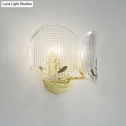 Contemporary gold arc light fixture wall sconce with gold finish and clear textured glass panels featuring leaf motif