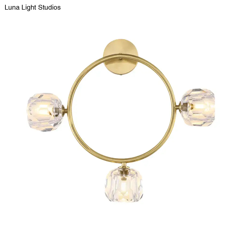 Contemporary gold brass wall light fixture with three faceted crystal globes for elegant bedroom lighting