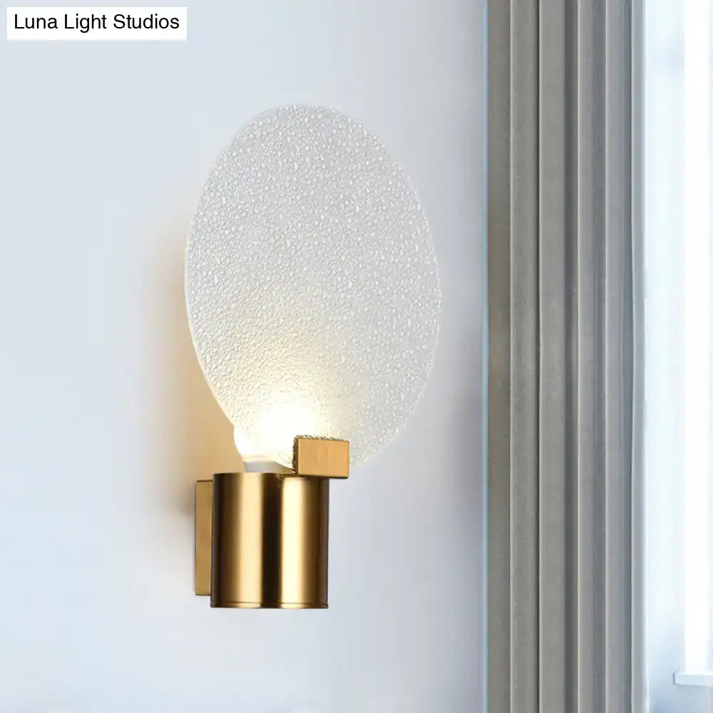Contemporary gold wall lamp with textured frosted bubble glass shade designed as a bedroom sconce