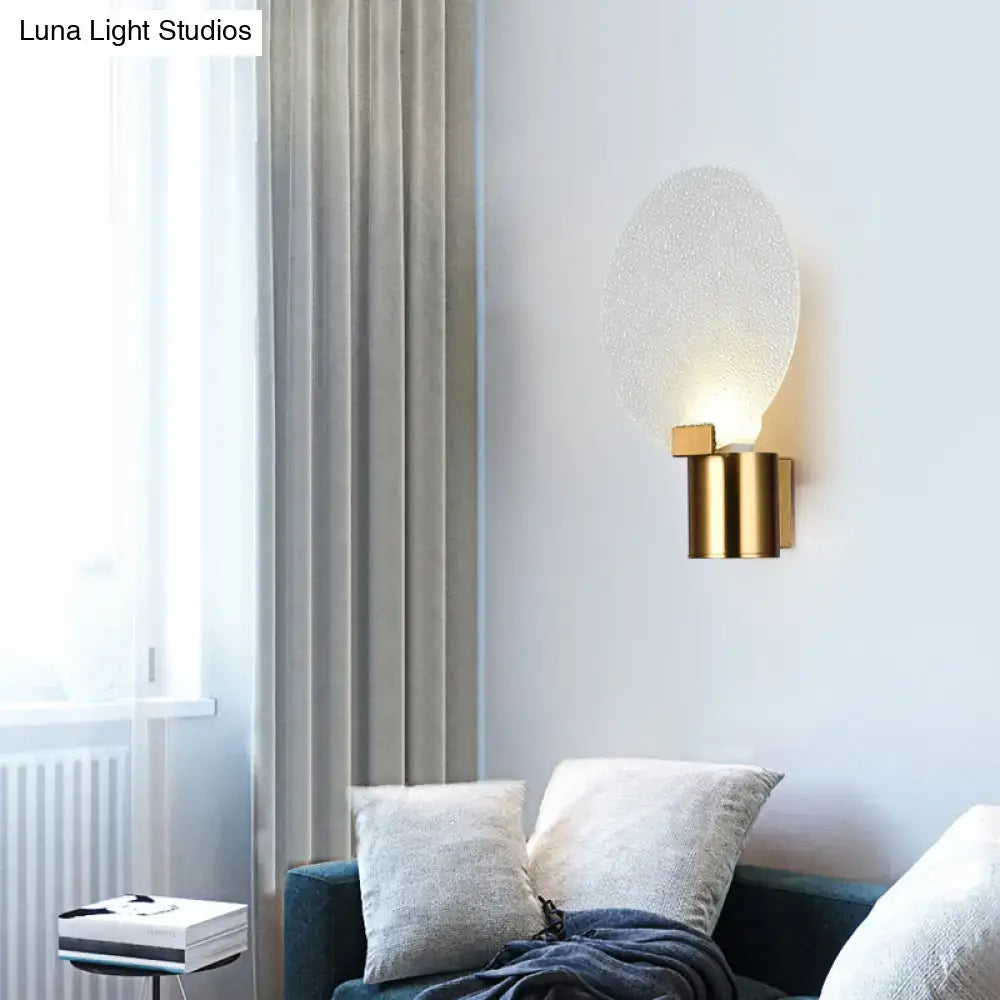 Contemporary gold wall lamp with bubble glass textured frosted oval shade ideal as a bedroom sconce