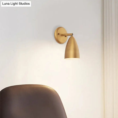 Contemporary brass-finished wall mount lamp with a sleek gold conical shade for bedroom spotlight lighting