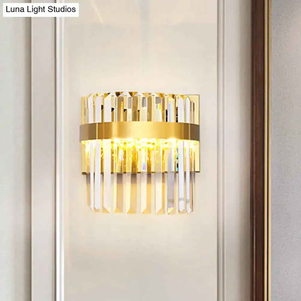 Contemporary gold-toned demilune cylinder wall light with vertical crystal prisms and central illuminated band for living room