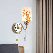 Contemporary wall lamp with gold finish metal frame and cream glass shade featuring pink cherry blossoms design