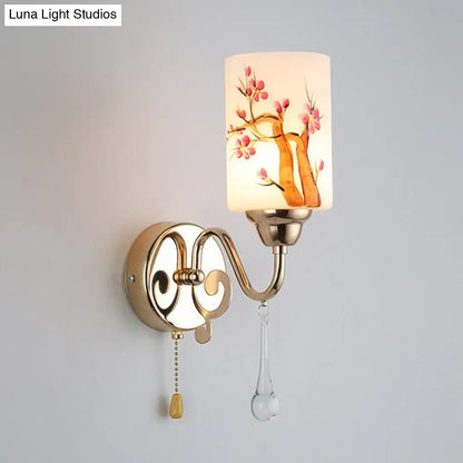 Contemporary wall lamp with gold finish and cream glass shade featuring hand-painted pink cherry blossoms