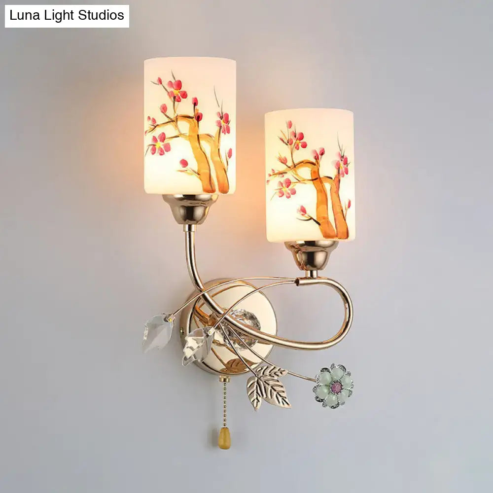 Contemporary wall lamp with gold finish, cream glass shade, and hand-painted cherry blossom design for bedroom use