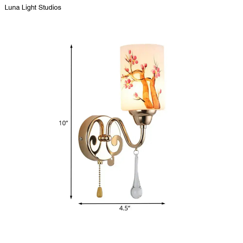 Contemporary wall lamp with gold finish brass frame and cream glass shade featuring pink cherry blossoms design