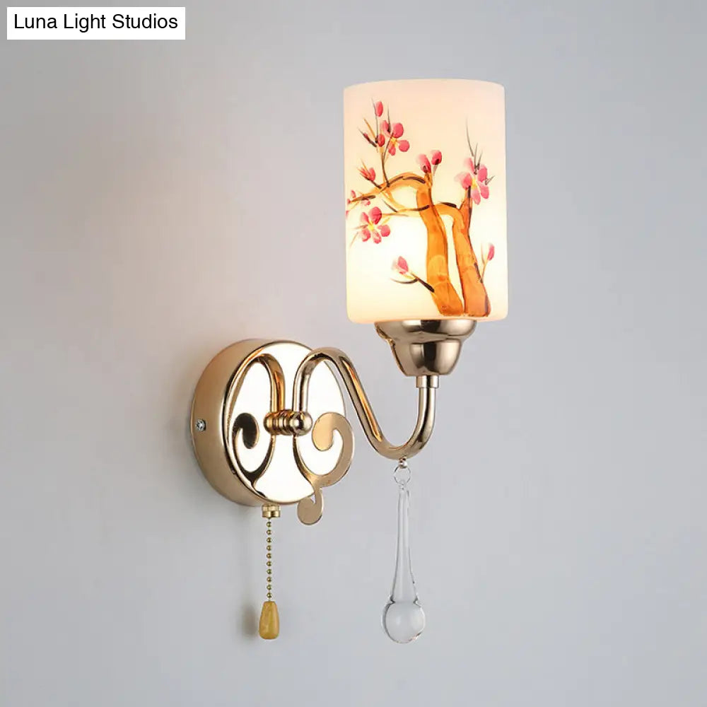 Lámpara de pared DecorBites™ de estilo contemporáneo con acabado dorado, pantalla de cristal color crema y cadena.