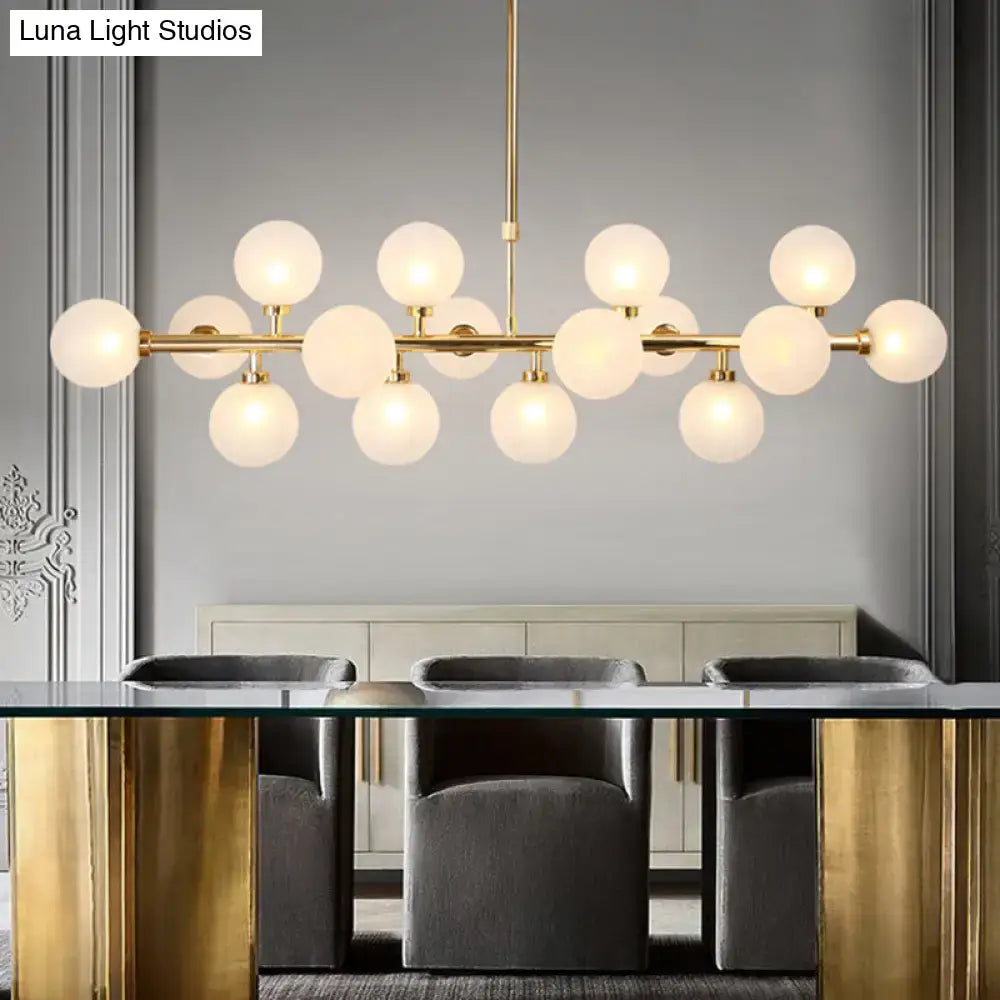Contemporary gold flush mount chandelier with frosted opal glass globe bulbs in a linear design for dining room