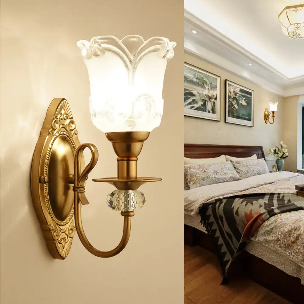 Contemporary gold wall lamp with frosted glass petal shade and crystal accent ideal for bedroom lighting