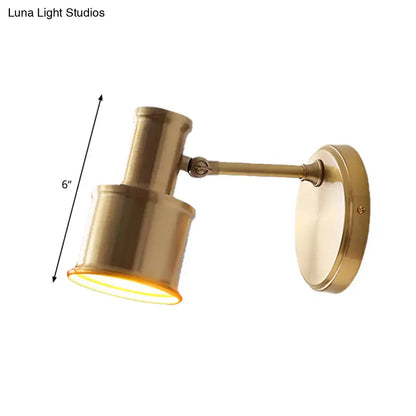 Contemporary brass-finished metal cylinder wall sconce with adjustable cylindrical shade and 6-inch length for bedroom reading