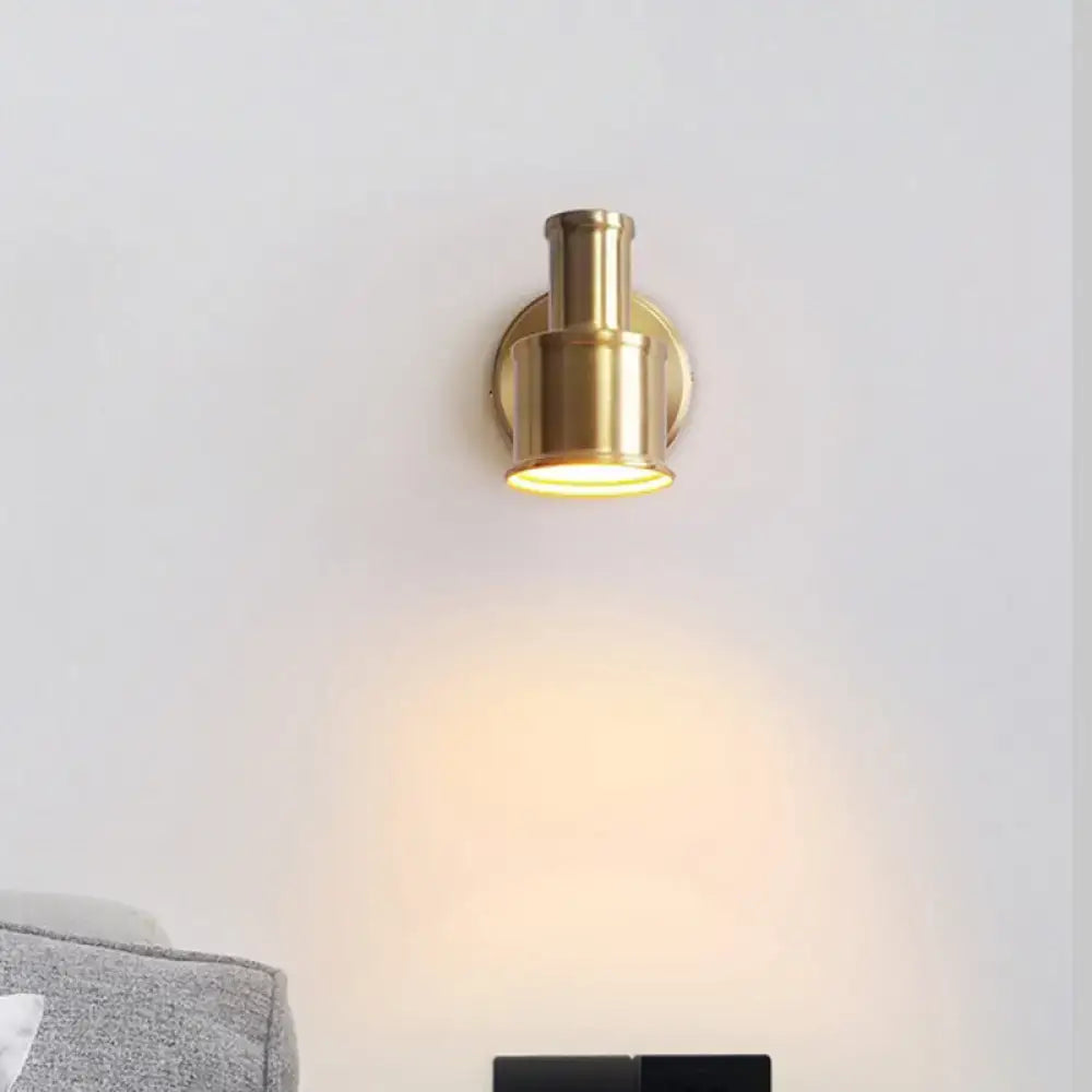 Contemporary brass finished metal cylinder wall sconce with warm focused illumination for bedroom spotlight use