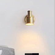 Contemporary brass finished metal cylinder wall sconce with warm focused illumination for bedroom spotlight use