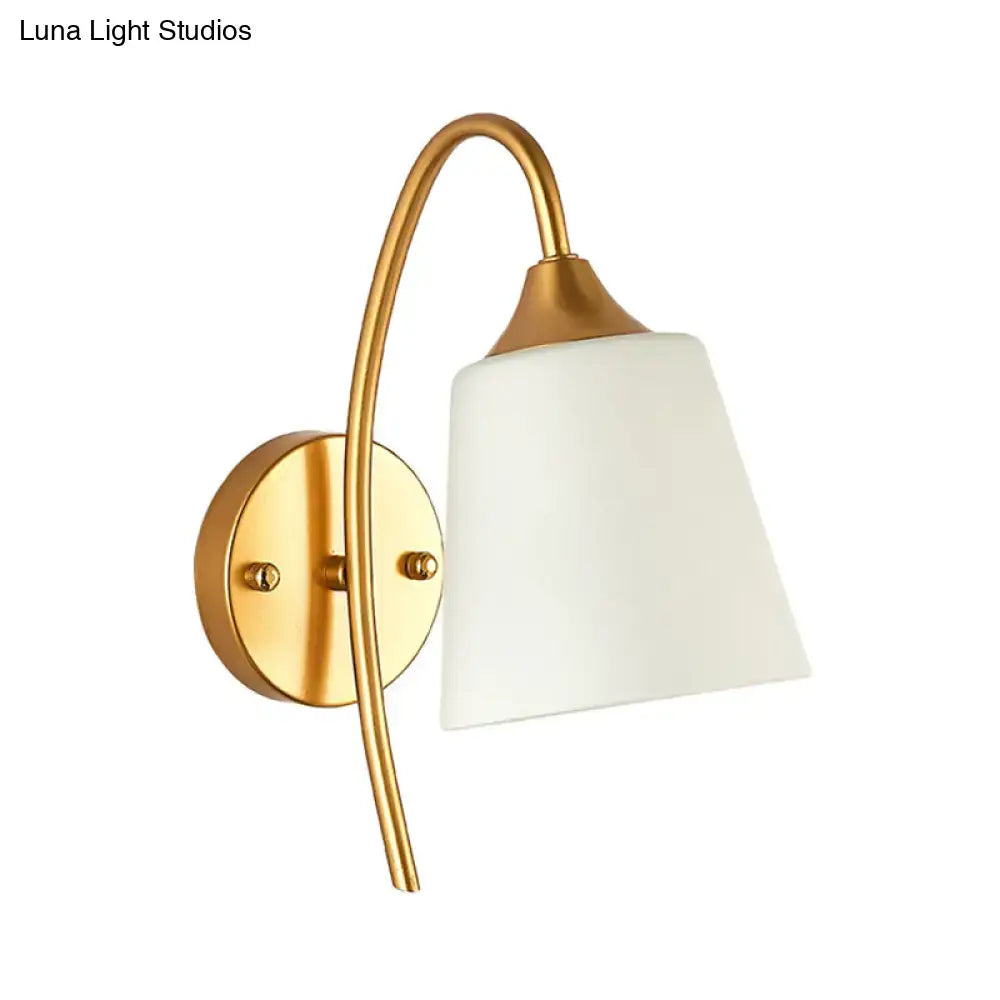 Contemporary gold milk glass wall lamp with a gold finish and white frosted glass shade for bedroom sconce lighting