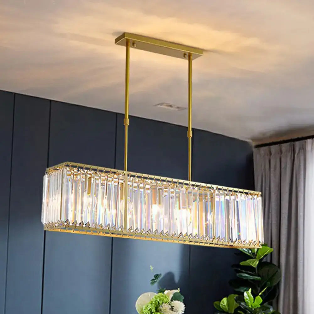 Contemporary gold-toned rectangular island pendant light with faceted tri-prism crystal accents for dining room ceiling