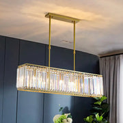 Contemporary gold-toned rectangular island pendant light with faceted tri-prism crystal accents for dining room ceiling