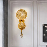 Contemporary gold-toned wall light with two textured sunburst glass discs and a tassel compatible with e12 e14 bulb