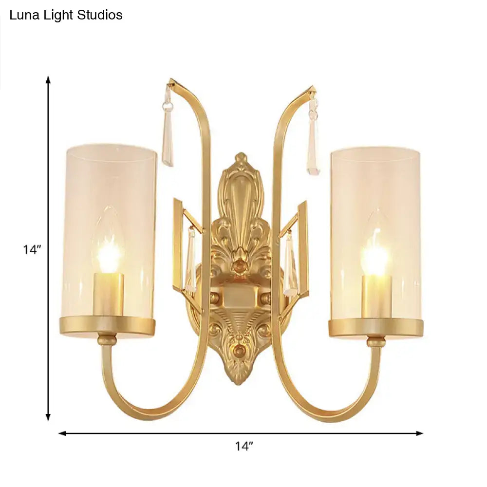 Contemporary gold wall light bedroom sconce with two cylindrical clear glass shades and ornate crystal accents