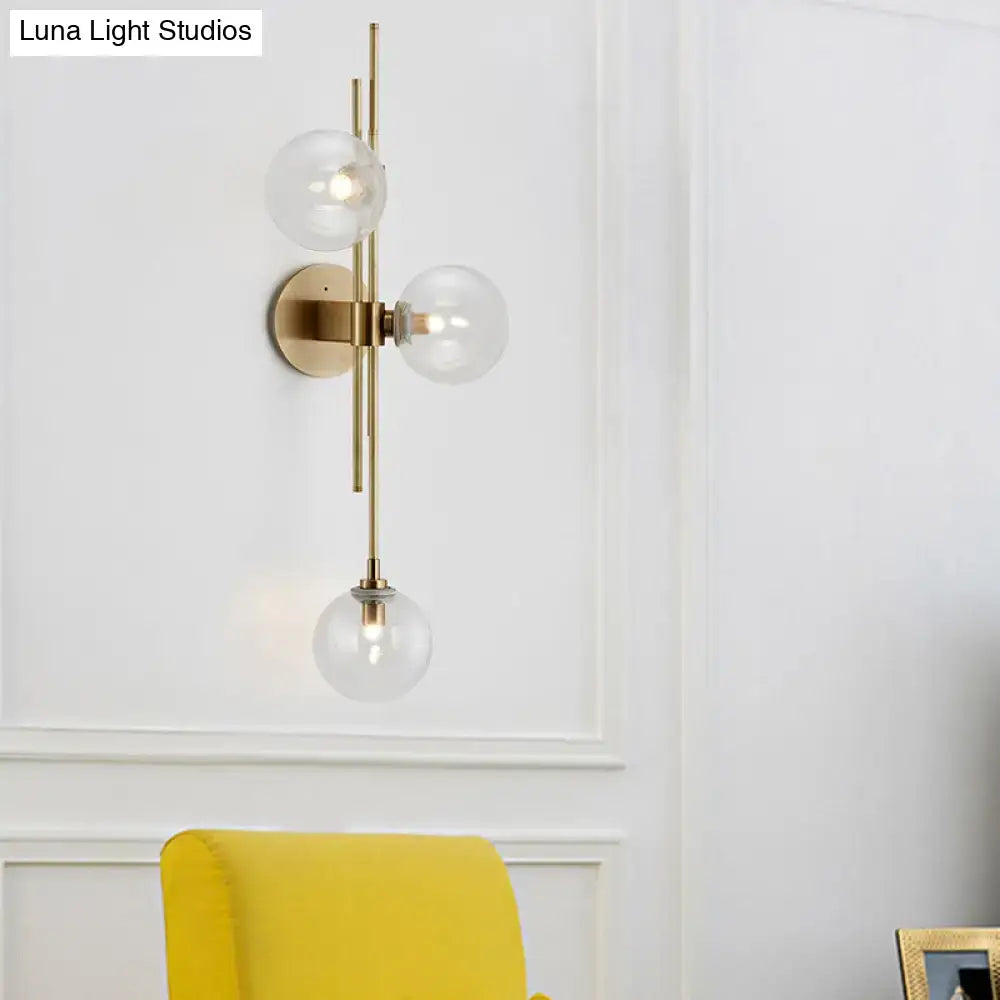 Contemporary green and clear glass globe living room wall sconce with modern brass finish and direct wired electric design