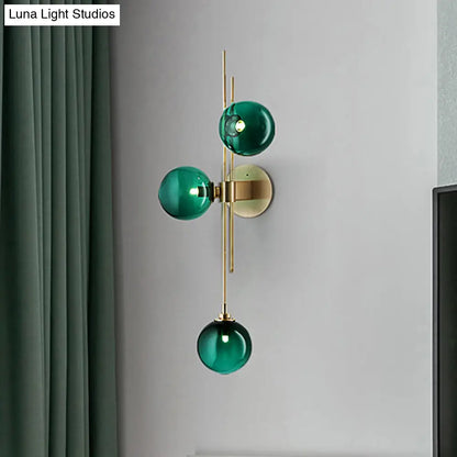Aplique de pared DecorBites™ contemporáneo con globo de cristal verde/transparente y 3 luces en latón