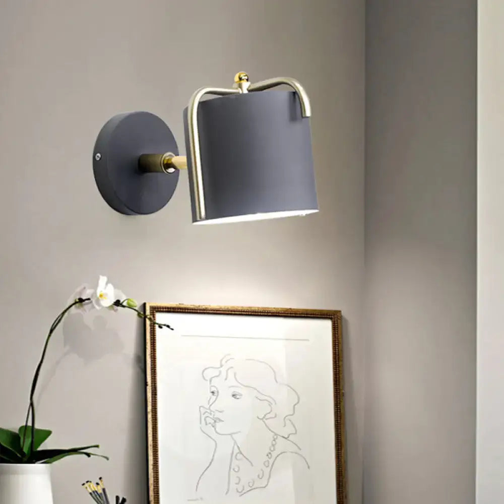 Contemporary green grey wall sconce with sleek cylindrical shade and brass accents for bedroom lighting