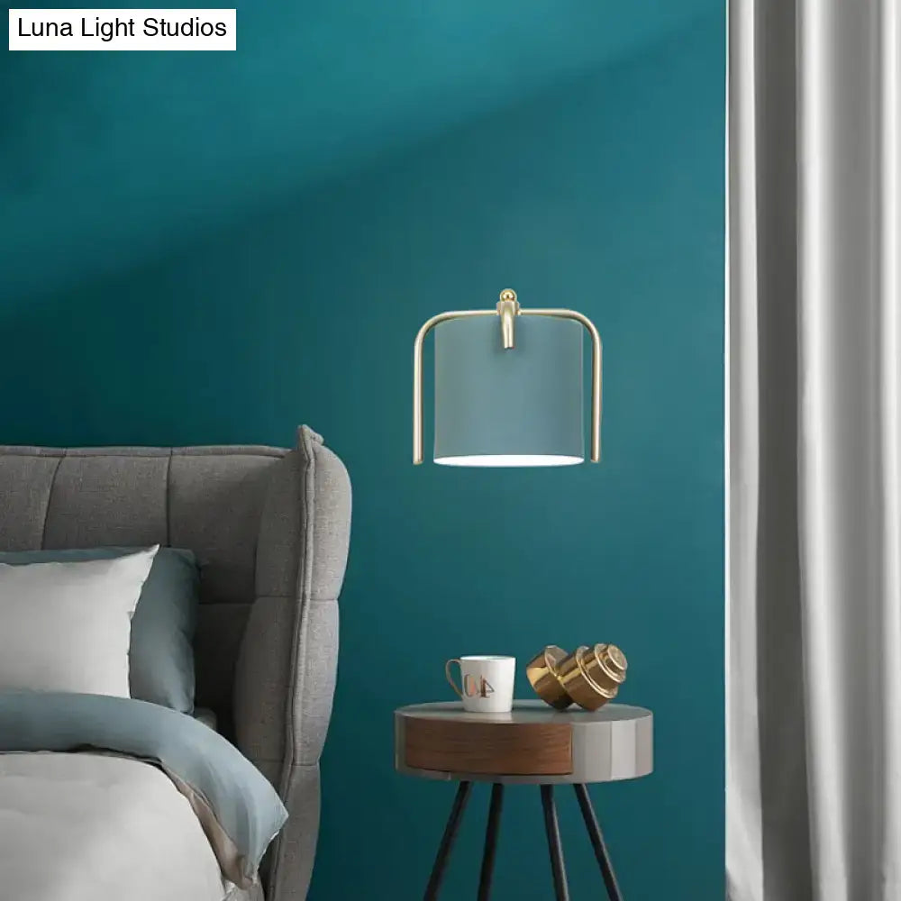 Contemporary green grey sconce with brass frame and translucent teal glass shade for bedroom lighting
