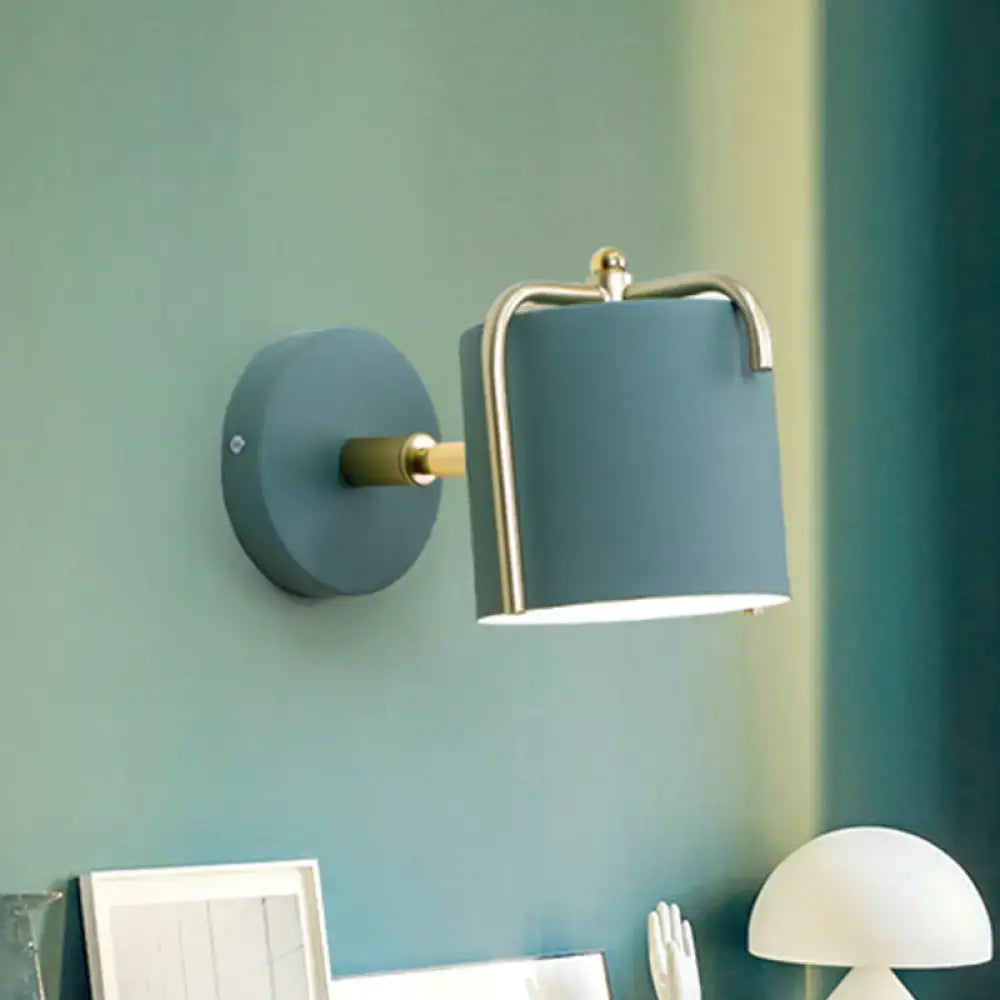 Contemporary green grey sconce featuring a blue cylindrical wall light with brass-finished metal frame for bedroom use