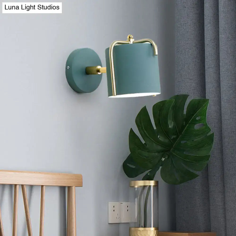 Contemporary green grey cylindrical wall sconce with brass accents designed for bedroom lighting