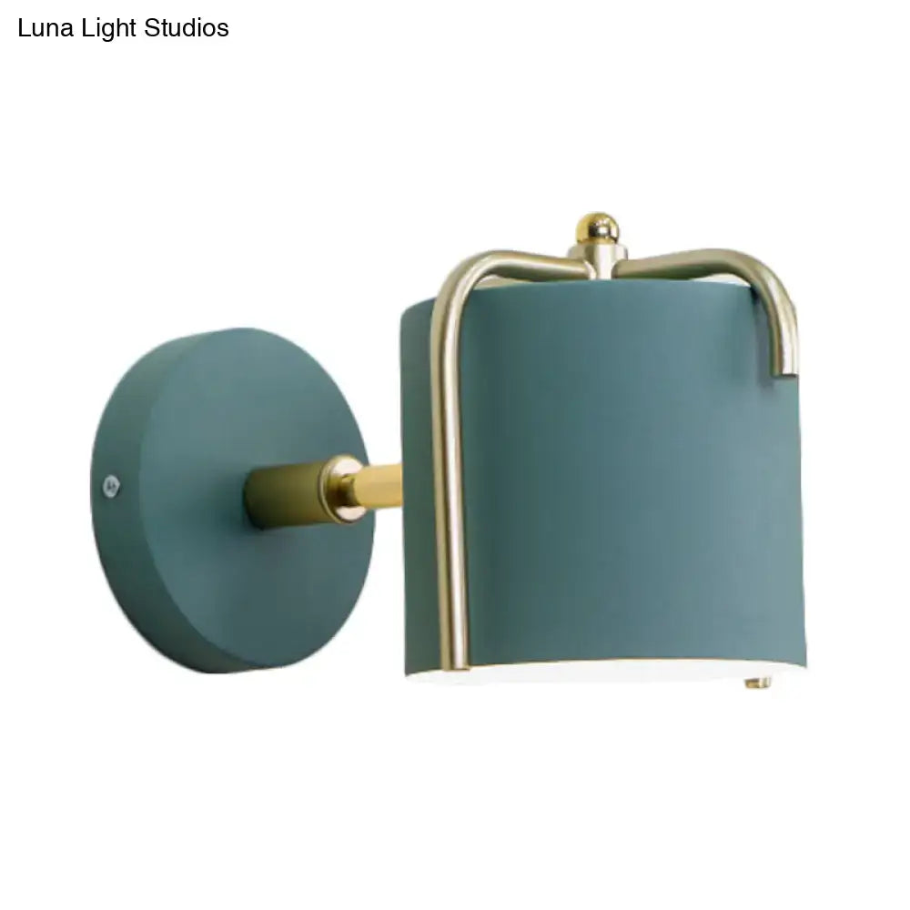Contemporary green grey sconce with teal matte finish brass accents and curved metal frame for bedroom lighting