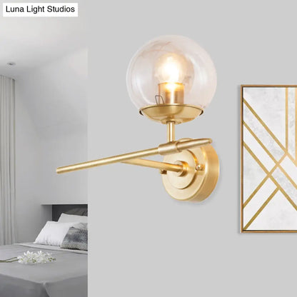 DecorBites™ DecorBites™ Contemporary Hand Blown Glass Wall Light with Brass Globe and Crossed Arm