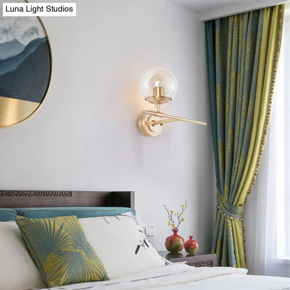 DecorBites™ DecorBites™ Contemporary Hand Blown Glass Wall Light with Brass Globe and Crossed Arm