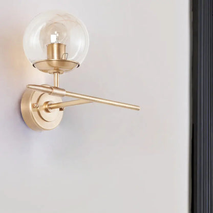 DecorBites™ DecorBites™ Contemporary Hand Blown Glass Wall Light with Brass Globe and Crossed Arm