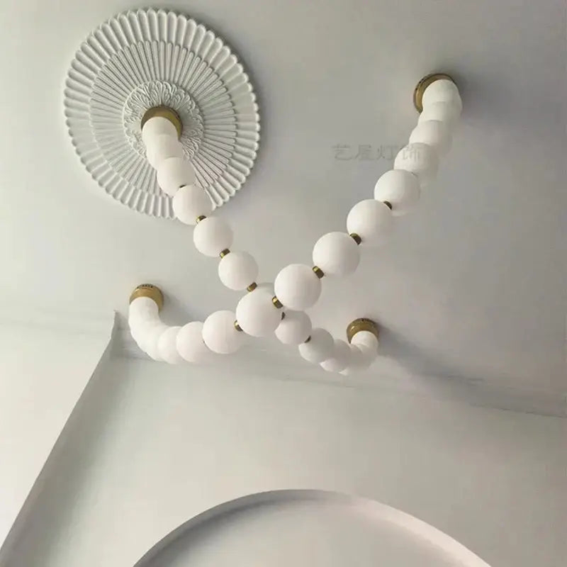 Contemporary led pendant chandeliers featuring white frosted glass globes with gold accents in a curved v-shape design