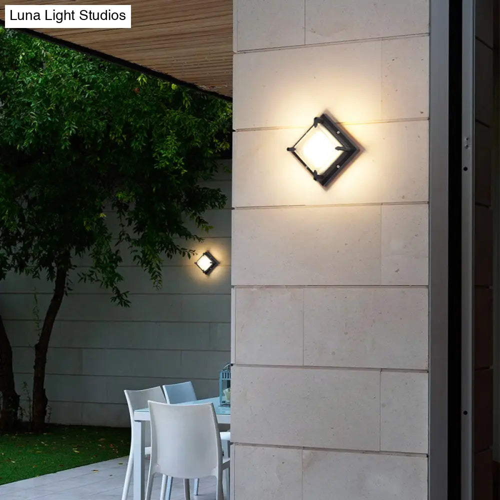 Aplique de pared cuadrado contemporáneo para patio DecorBites™ con luz LED, en color negro con cristal esmerilado.