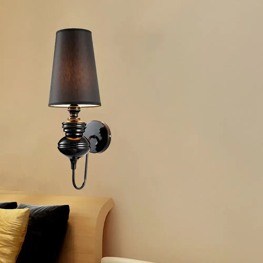 Contemporary black wrought iron wall mount light with a matte black fabric shade for bedroom use